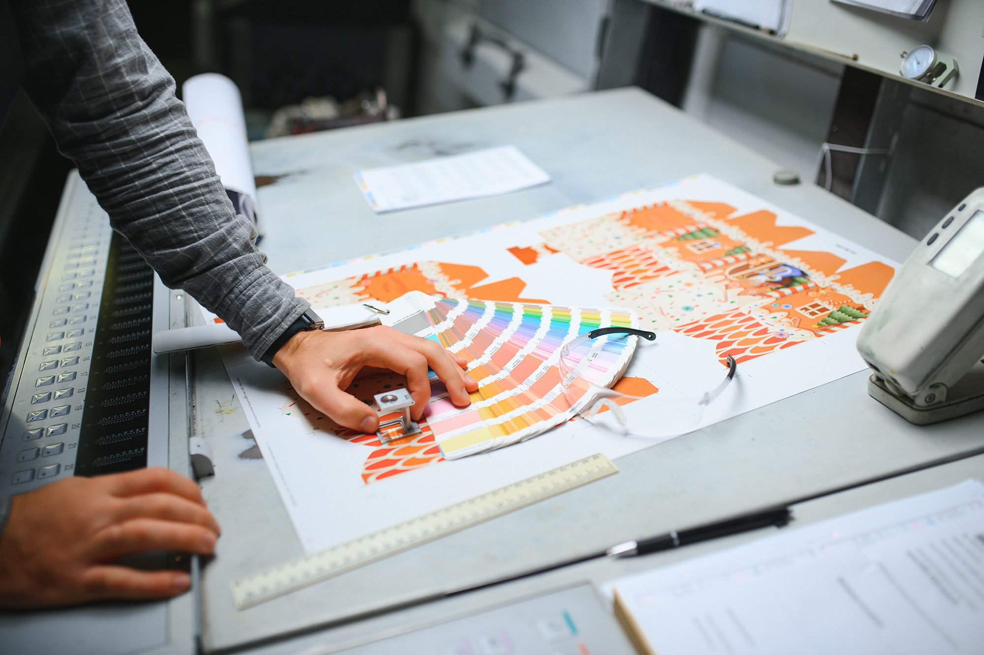 print-house-worker-controlling-printing-process-quality-and-checking-colors-with-magnifying-glass